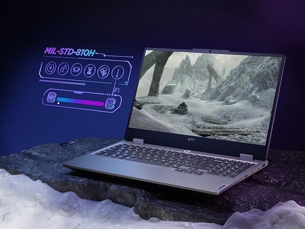 Игровой ноутбук Lenovo LOQ 15IAX9, вид справа спереди с открытой крышкой. На экране изображение арктического пейзажа. Рядом с устройством представлено графическое изображение характеристик по стандарту MIL-STD 810H.